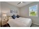 This is a bedroom with a double bed, ceiling fan, wood-look flooring and a window at 17873 Grand Prosperity Dr, Venice, FL 34293