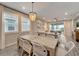 Bright dining area open to the living room with a decorative chandelier and large windows at 17873 Grand Prosperity Dr, Venice, FL 34293