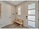 Inviting entryway featuring a bench with storage and a frosted glass door, bathed in natural light at 17873 Grand Prosperity Dr, Venice, FL 34293