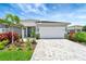 Charming single-story home with a two-car garage, beautiful landscaping, and a paver driveway at 17873 Grand Prosperity Dr, Venice, FL 34293