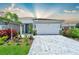 Charming single-story home with a two-car garage, beautiful landscaping, and a paver driveway at 17873 Grand Prosperity Dr, Venice, FL 34293