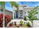 Inviting front porch with seating, beautiful landscaping, and a stylish front door at 17873 Grand Prosperity Dr, Venice, FL 34293
