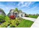 Beautifully landscaped front yard with lush greenery, a paver driveway, and a charming exterior at 17873 Grand Prosperity Dr, Venice, FL 34293