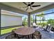 Covered lanai with outdoor seating and views of the community's landscaping and lake at 17873 Grand Prosperity Dr, Venice, FL 34293