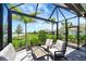 Screened lanai with lounge seating overlooking the community's lush landscaping and lake at 17873 Grand Prosperity Dr, Venice, FL 34293
