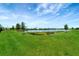 Scenic pond view featuring lush greenery and blue skies, creating a serene and picturesque landscape at 17873 Grand Prosperity Dr, Venice, FL 34293