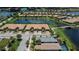 Aerial view of a townhome community with lush landscaping, a scenic lake, and a charming bridge at 19269 Serafina St, Venice, FL 34293