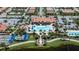 An aerial view shows a community center, pool, tennis courts, bocce ball, and ample parking in this desirable community at 19269 Serafina St, Venice, FL 34293