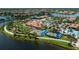 Aerial view of the community clubhouse featuring a pool, bocce ball, and lush landscaping at 19269 Serafina St, Venice, FL 34293