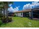 A covered lanai and screen room accent the rear exterior of this home with a meticulously maintained lawn and landscaping at 19269 Serafina St, Venice, FL 34293