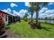 A well-manicured lawn featuring palm trees and a screened-in lanai overlooking a serene lake at 19269 Serafina St, Venice, FL 34293