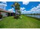 A well-manicured backyard featuring palm trees and a screened-in lanai overlooking a serene lake at 19269 Serafina St, Venice, FL 34293