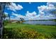 A tranquil lakeside view with a bridge, lush greenery, and blue skies at 19269 Serafina St, Venice, FL 34293