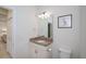 This bathroom features granite countertops, a toilet, and a mirror with overhead lighting at 19269 Serafina St, Venice, FL 34293