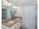Bright bathroom features a double sink vanity with granite countertops and modern fixtures and a decorative plant at 19269 Serafina St, Venice, FL 34293