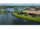 Aerial view of a waterfront home with a bridge, lake, palms, and beautiful landscaping at 19269 Serafina St, Venice, FL 34293