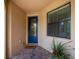 Inviting covered entryway with a decorative blue front door, brick pavers, and a welcome mat at 19269 Serafina St, Venice, FL 34293