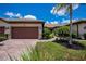 Inviting front exterior boasts a paver driveway, well-manicured landscaping, and a neutral color palette with a brown tile roof at 19269 Serafina St, Venice, FL 34293