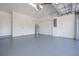 Spacious garage featuring a gray epoxy floor, storage racks, and ample space for parking and storage solutions at 19269 Serafina St, Venice, FL 34293