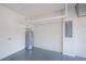 Clean garage showcasing a grey epoxy floor, overhead storage racks, an electric panel, and a water heater at 19269 Serafina St, Venice, FL 34293