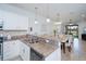 Open kitchen featuring granite countertops, white cabinetry, pendant lighting, and stainless steel appliances at 19269 Serafina St, Venice, FL 34293