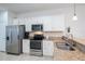 Bright kitchen with stainless steel appliances, granite countertops, white cabinetry, and tile flooring at 19269 Serafina St, Venice, FL 34293
