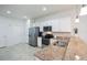 Bright kitchen featuring granite countertops, white cabinetry, stainless appliances, and tile flooring at 19269 Serafina St, Venice, FL 34293