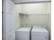 Functional laundry room with modern white washer and dryer, plus wire shelving at 19269 Serafina St, Venice, FL 34293