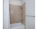 This shower features tan tiled walls, a white shower curtain, and a rainfall shower head at 19269 Serafina St, Venice, FL 34293