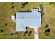 Aerial view of a home with a grey roof and large yard with palm trees and lush grass at 20430 Edgewater Dr, Port Charlotte, FL 33952