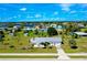 Aerial view of a single-Gathering home featuring a spacious yard with mature trees and landscaping at 20430 Edgewater Dr, Port Charlotte, FL 33952