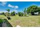 Large, grassy backyard featuring mature trees and landscaping, ideal for outdoor activities at 20430 Edgewater Dr, Port Charlotte, FL 33952