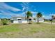 Charming single-story home with well-maintained lawn and tropical palm trees in front yard at 20430 Edgewater Dr, Port Charlotte, FL 33952