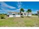 Charming single-story home with well-maintained lawn and tropical palm trees in front yard at 20430 Edgewater Dr, Port Charlotte, FL 33952