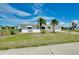 Charming single-story home with well-maintained lawn and tropical palm trees in front yard at 20430 Edgewater Dr, Port Charlotte, FL 33952