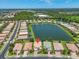 Stunning aerial view of a waterfront property in a residential neighborhood with lush landscaping and a nearby lake at 2146 Snapdragon Ln, Venice, FL 34292