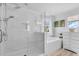 Bright bathroom with glass shower, soaking tub, tile surround, and double shower heads at 2146 Snapdragon Ln, Venice, FL 34292