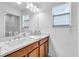 Bathroom featuring double sinks, cherry cabinets, marble countertop, and natural light at 2146 Snapdragon Ln, Venice, FL 34292