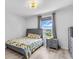 Bedroom with patterned comforter, hardwood style floors, ceiling light and a dresser at 2146 Snapdragon Ln, Venice, FL 34292
