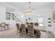 Formal dining area with modern chandelier lighting, a large dining table, and staircase views at 2146 Snapdragon Ln, Venice, FL 34292