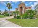 Beautiful two-story home featuring a paver driveway, a two-car garage, and lush landscaping with mature palm trees at 2146 Snapdragon Ln, Venice, FL 34292