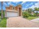 Charming home with a two-car garage, tile roof, paver driveway, and well-manicured landscaping including palm trees at 2146 Snapdragon Ln, Venice, FL 34292