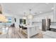 Eat-in kitchen with granite countertops, stainless steel appliances, and an island with seating, all with a lake view at 2146 Snapdragon Ln, Venice, FL 34292