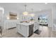 Gourmet kitchen with an island, stainless steel appliances, custom cabinets, and a lake view through sliding glass doors at 2146 Snapdragon Ln, Venice, FL 34292