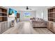 Open concept living room with plush sofa, hardwood floors, ceiling fan, and natural light at 2146 Snapdragon Ln, Venice, FL 34292