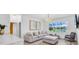 Bright living room with plush seating, wood flooring, and large windows overlooking a lake at 2146 Snapdragon Ln, Venice, FL 34292