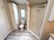 Bathroom features a walk-in shower and a toilet and sink with modern lighting and tiled flooring at 217 Blackburn Blvd, North Port, FL 34287