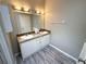 Bathroom features double sinks and modern lighting with an ample vanity and tiled flooring at 217 Blackburn Blvd, North Port, FL 34287