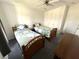 Bedroom featuring two twin beds with wooden frames, a dresser, a door, and a ceiling fan at 217 Blackburn Blvd, North Port, FL 34287