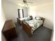 Bedroom featuring two twin beds with wooden frames, a dresser, and a ceiling fan at 217 Blackburn Blvd, North Port, FL 34287